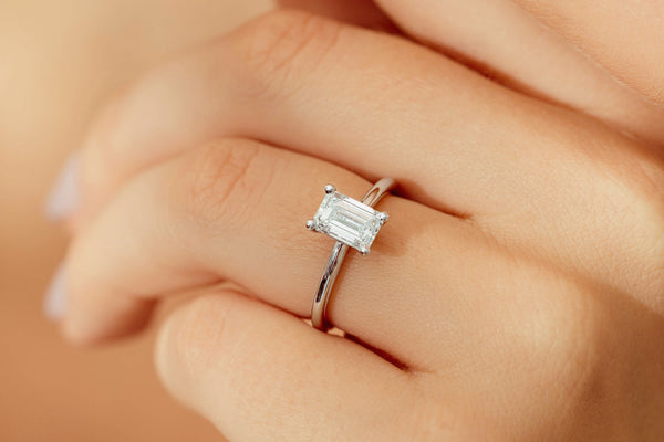 Close up of emerald cut diamond solitaire ring on a hand