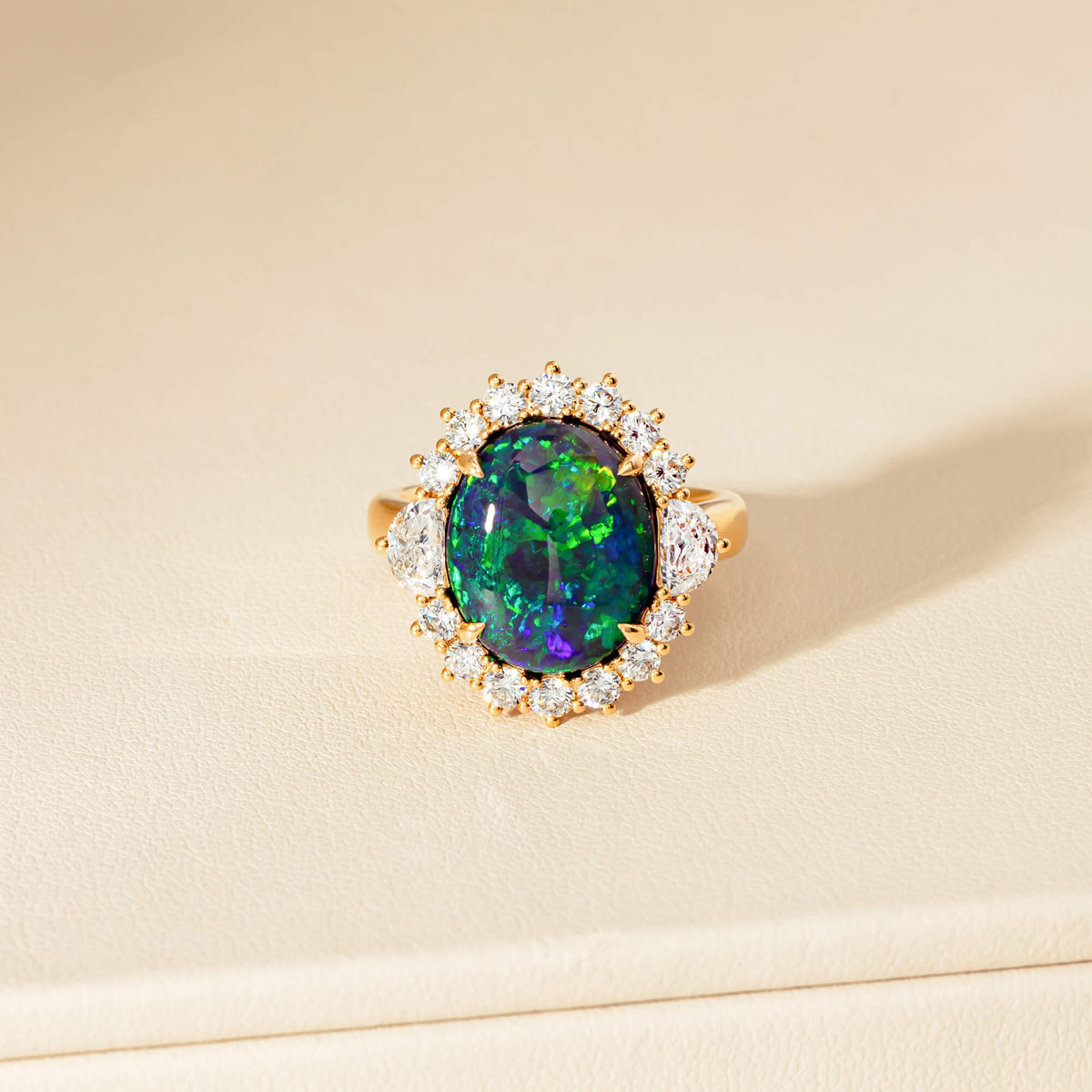 Close up of an opal and diamond ring on a neutral background