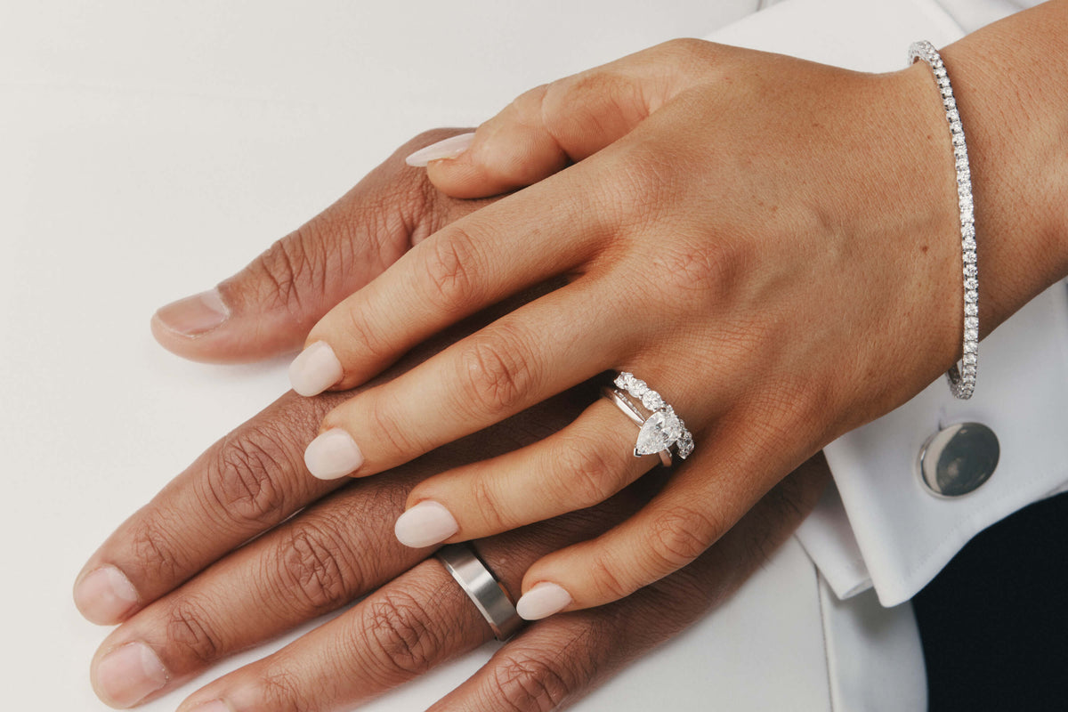 Close up of bride wearing pearl cut diamond solitaire ring