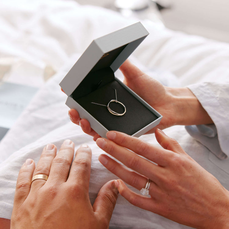 Model holding Entwined Pendant in Walker & Hall box