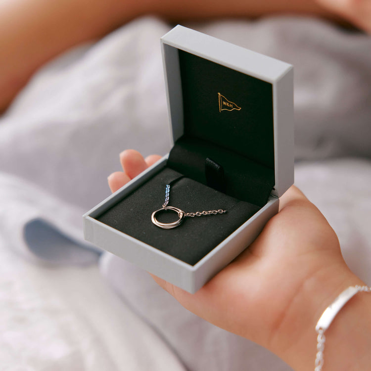Model holding Entwined Pendant in Walker & Hall jewellery box